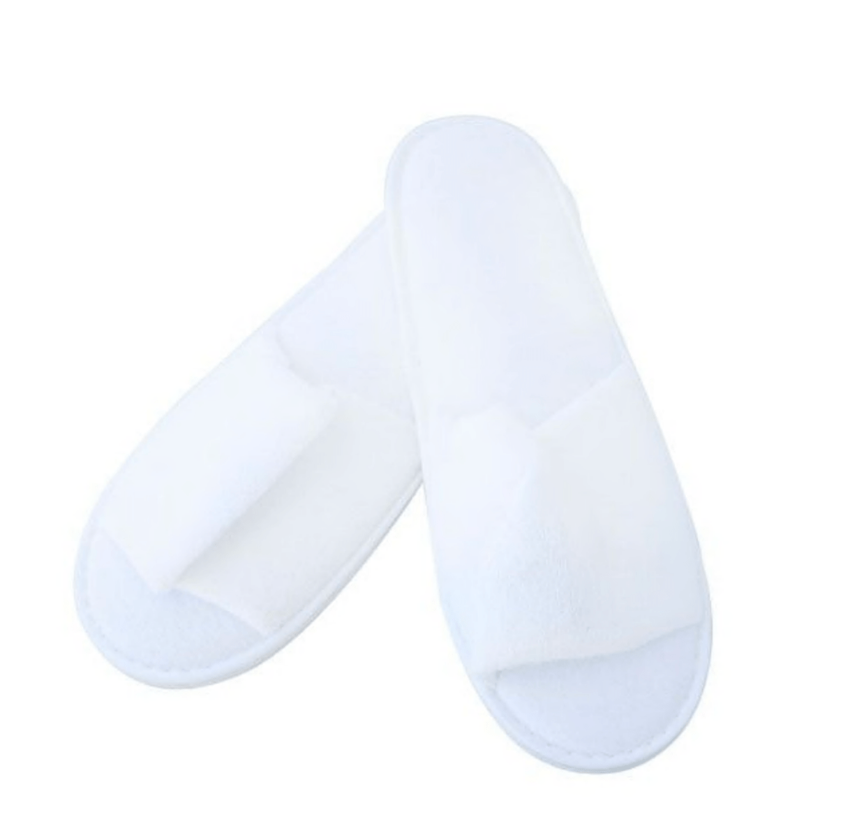 Zacht wit badstof slippers met open teen, een paar, liggend op een neutrale ondergrond