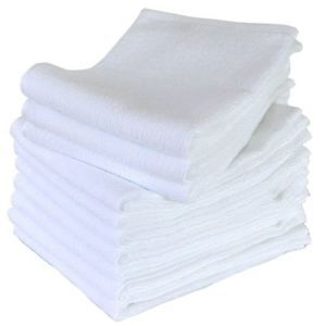 Witte professionele kompresdoek van 100% katoen, opgevouwen en klaar voor gebruik in een salon.