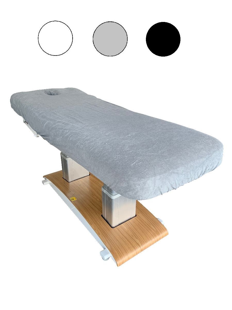 Witte badstof massagebankhoes met gat, strak over een behandeltafel getrokken, toont comfort en hygiëne.