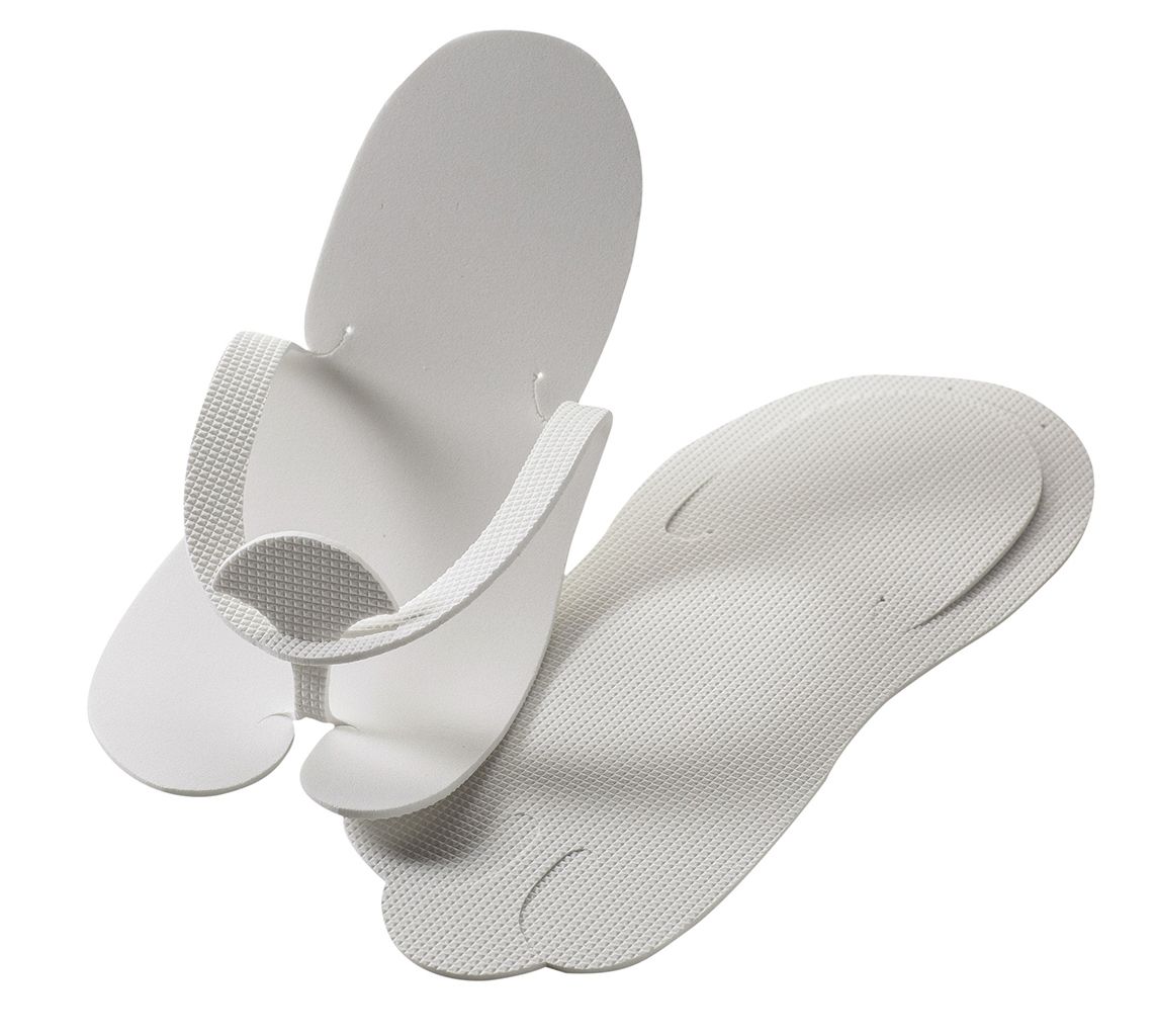 Twee witte wegwerp teenslippers van EVA-materiaal, liggend op een schone ondergrond, klaar voor gebruik in een salon of wellnessomgeving